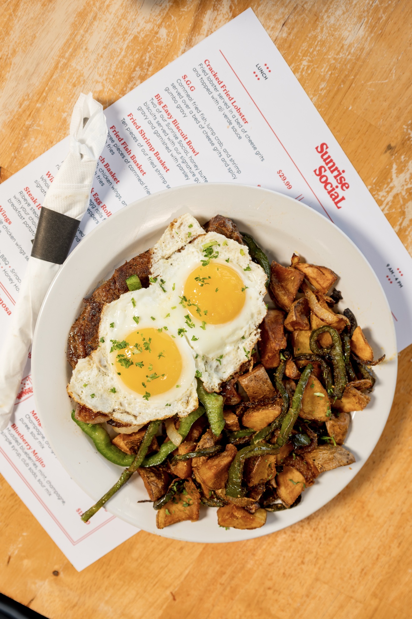 Sunrise Social steak and eggs served with seasoned breakfast potatoes and peppers